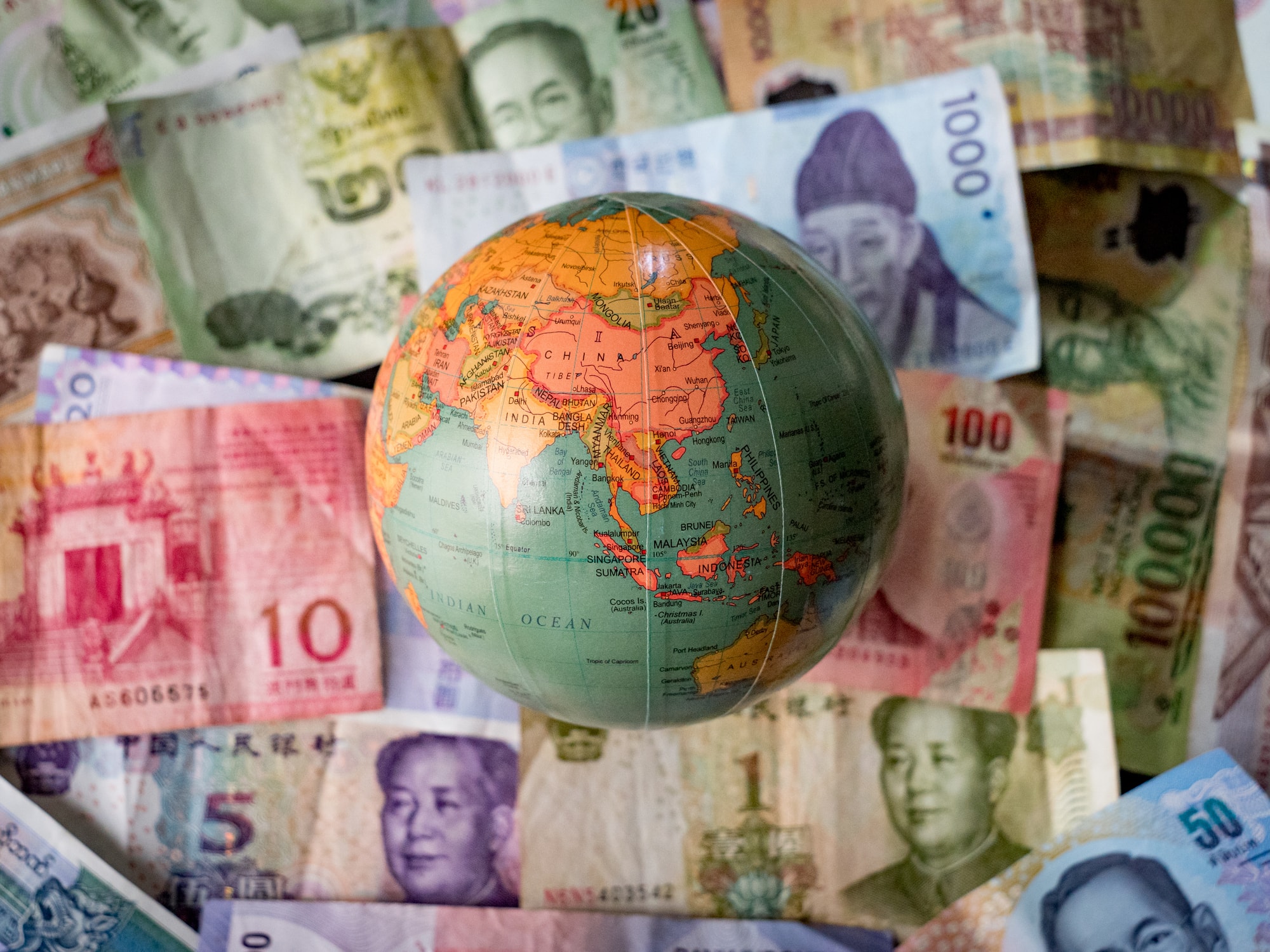 Globe sitting on top of international money.